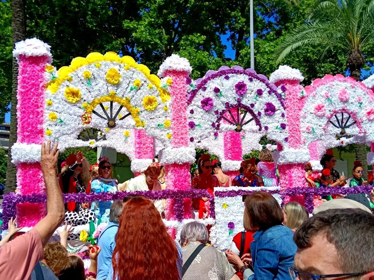 Carroza con grandes abanicos de flores amarillas, blancas y moradas