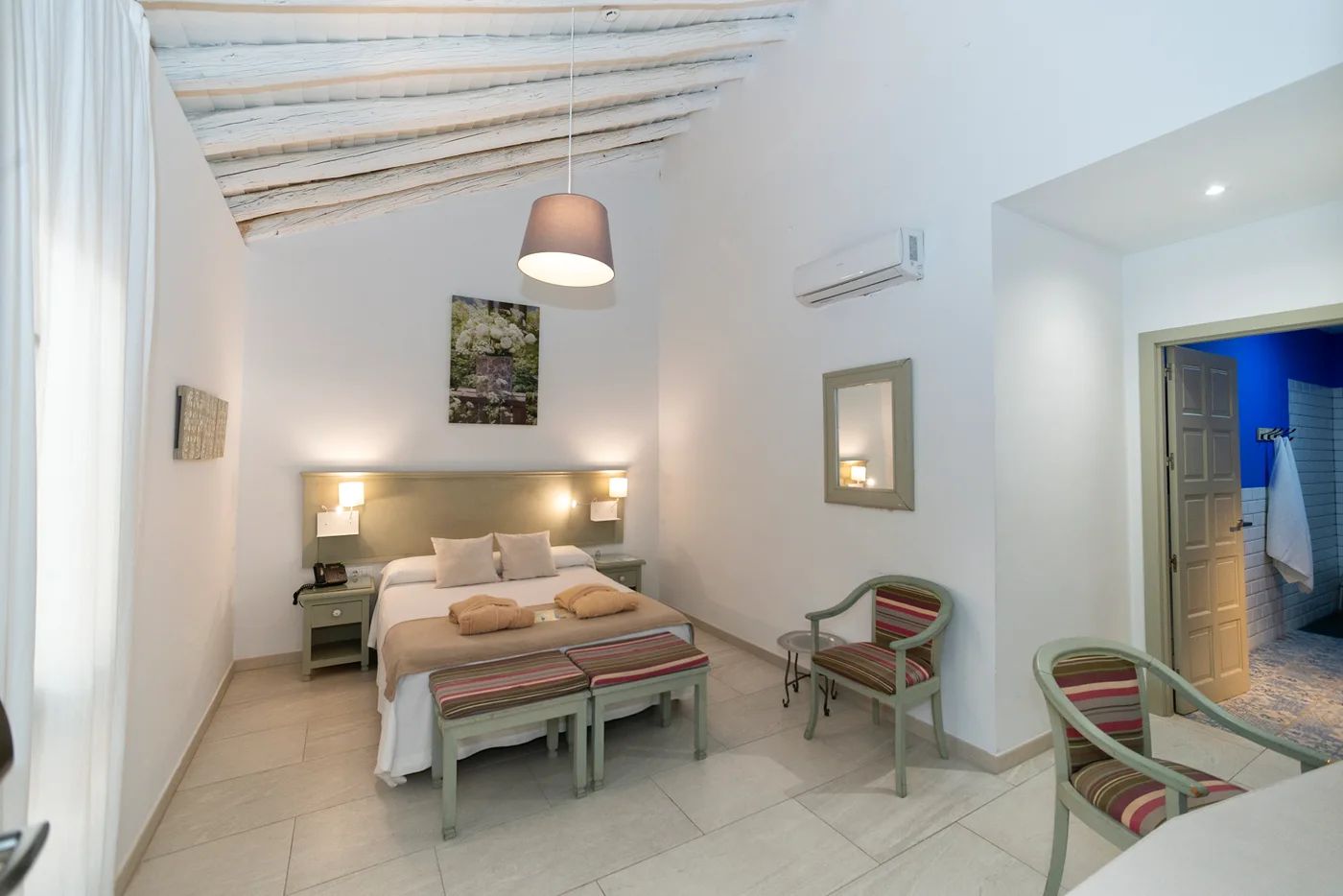 Habitación de la hospedería con techo de rollizos de madera