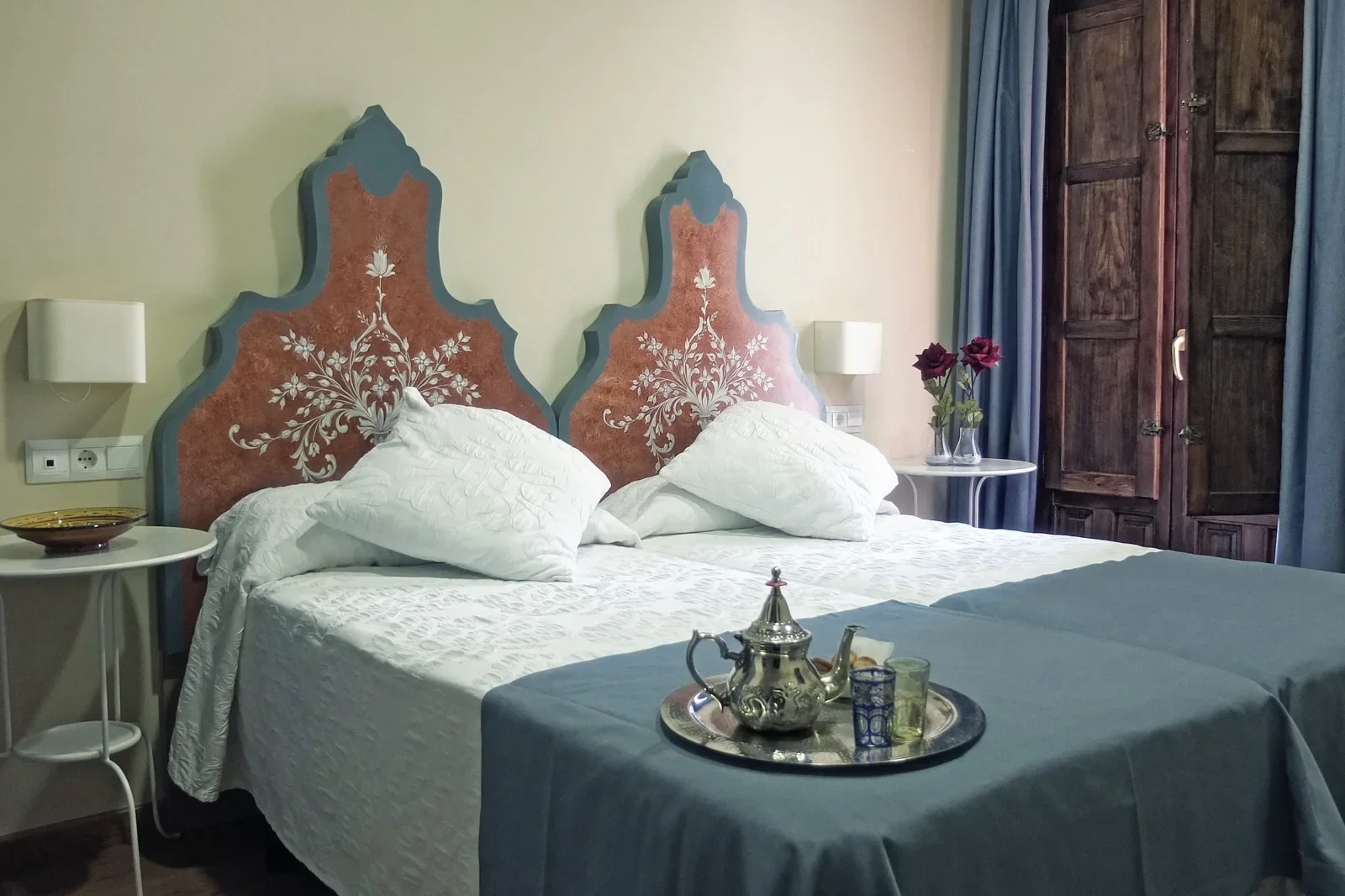 Habitación de la hospedería con cabeceros pintados y bandeja de té